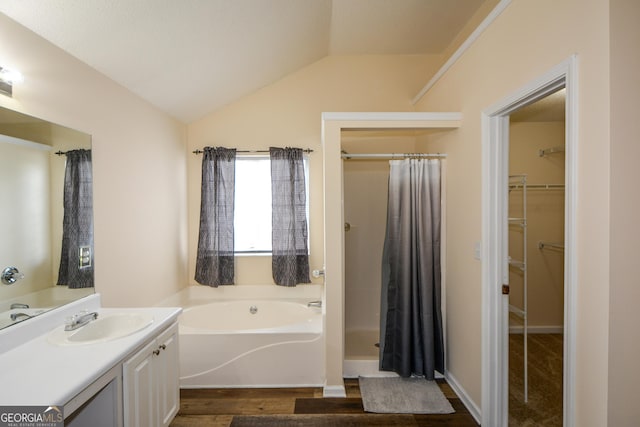 bathroom featuring wood finished floors, a shower with curtain, a garden tub, vanity, and a walk in closet
