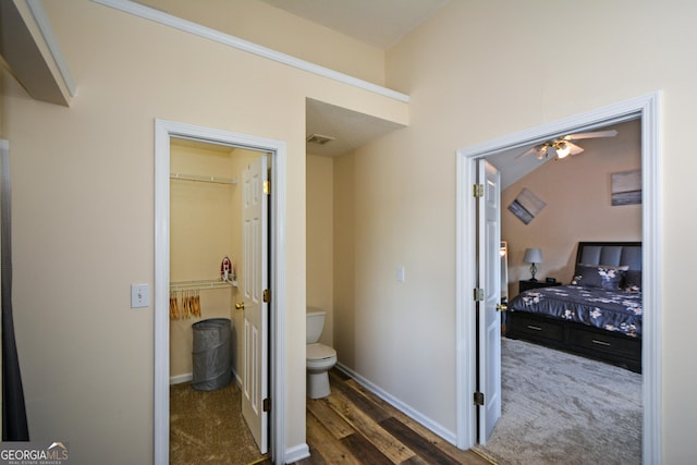bathroom with toilet, ceiling fan, baseboards, and wood finished floors