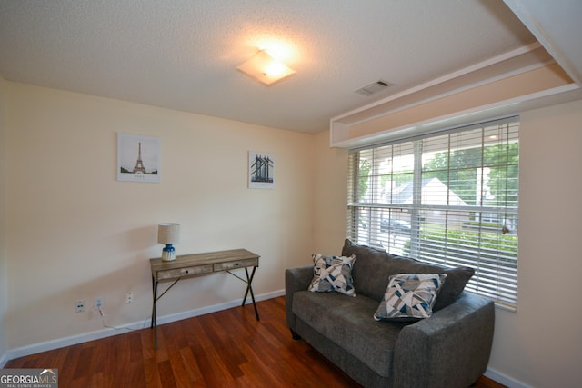 sitting room featuring wood finished floors, baseboards, and a textured ceiling