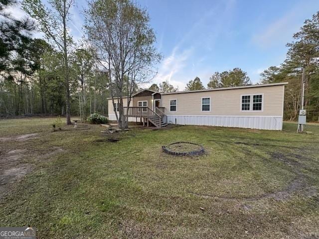 back of property featuring stairway, a wooden deck, and a lawn