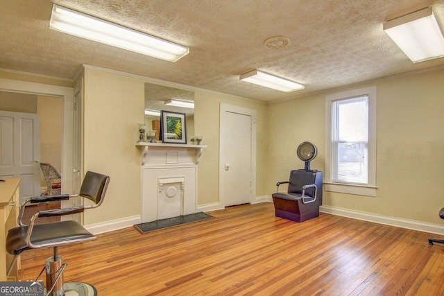 808 S Broad St, Monroe, GA 30655 - sitting room with baseboards, light wood finished floors, crown molding, and a textured ceiling