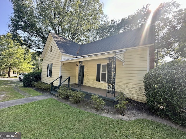 808 S Broad St, Monroe, GA 30655 - view of front of house with a front lawn, stone siding, a shingled roof, and covered porch