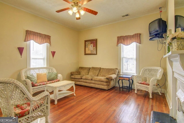 808 S Broad St, Monroe, GA 30655 - living room featuring ceiling fan, ornamental molding, wood-type flooring, and visible vents