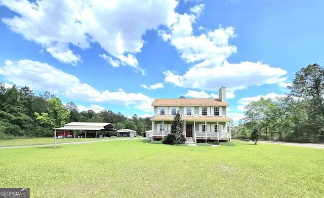 rear view of property featuring a yard, a chimney, a porch, and a carport