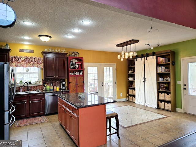 kitchen featuring french doors, a sink, a kitchen breakfast bar, open shelves, and appliances with stainless steel finishes