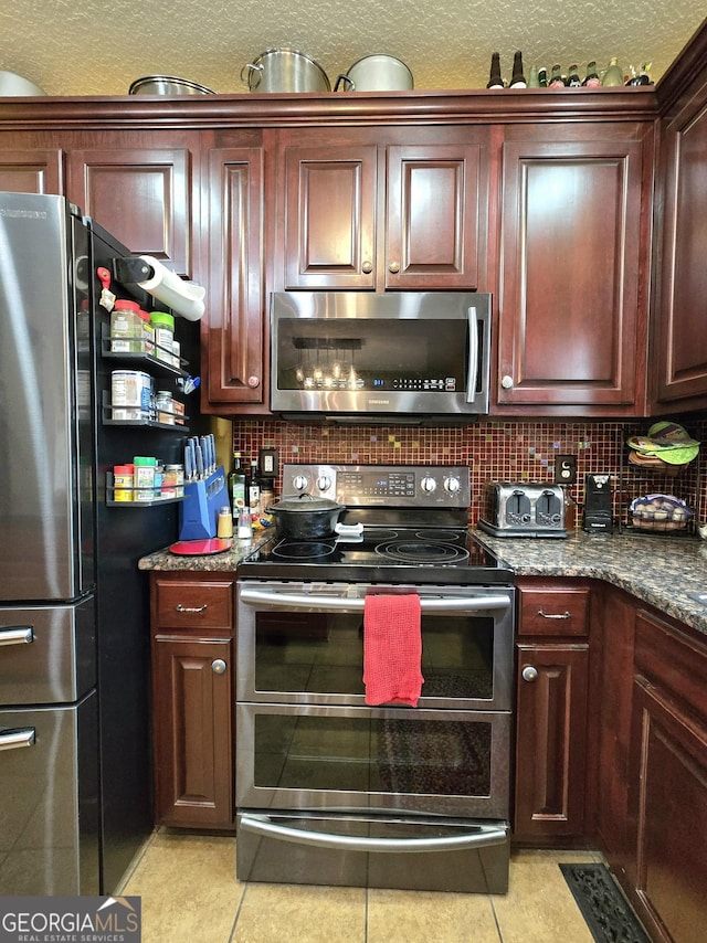 kitchen featuring stainless steel appliances, tasteful backsplash, and light tile patterned flooring