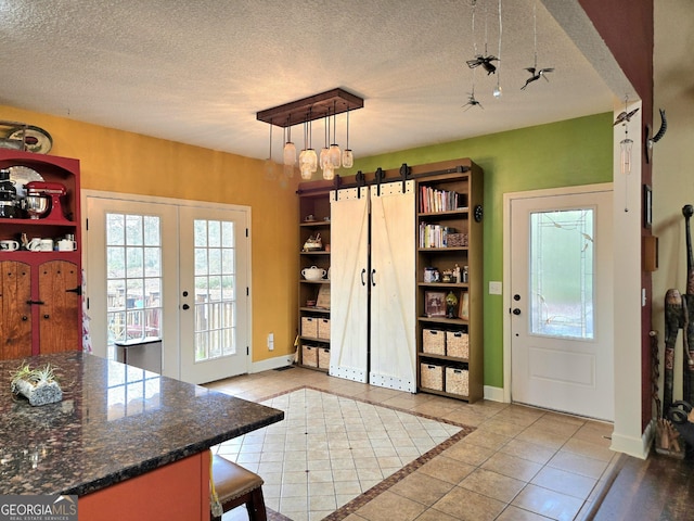 doorway featuring tile patterned floors, a textured ceiling, french doors, and baseboards