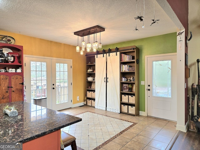 doorway to outside with baseboards, french doors, light tile patterned flooring, and a textured ceiling