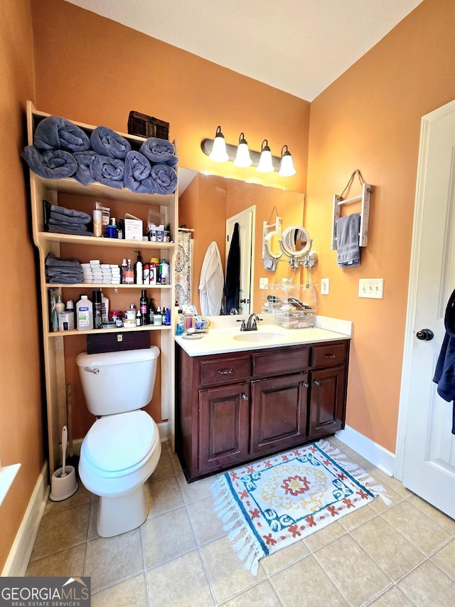 bathroom with toilet, a shower with shower curtain, baseboards, tile patterned flooring, and vanity