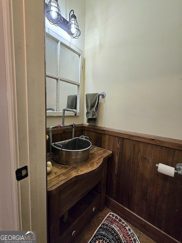 bathroom with wainscoting, vanity, and wood walls