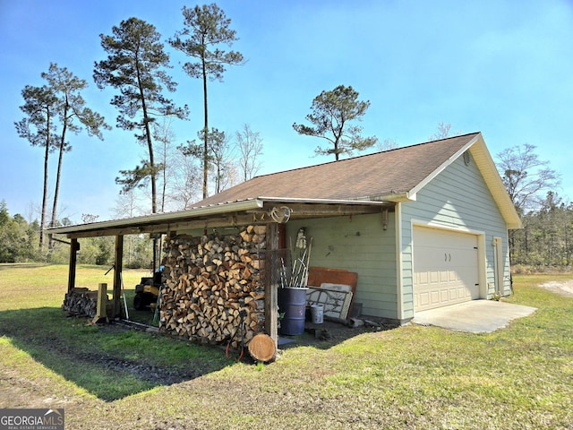 view of home's exterior with a yard, an outbuilding, a shingled roof, and a detached garage