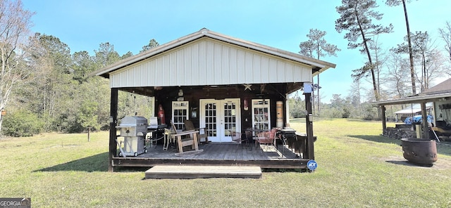 deck with area for grilling, french doors, and a lawn