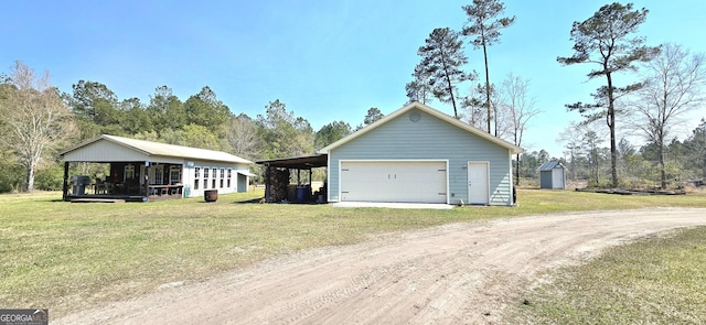 garage featuring driveway, a garage, and a storage shed