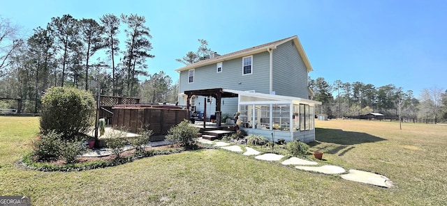 back of property with a yard, a deck, a sunroom, and fence