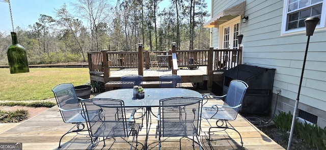 wooden terrace with a yard and outdoor dining space