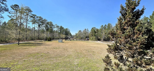 view of yard featuring fence and a forest view
