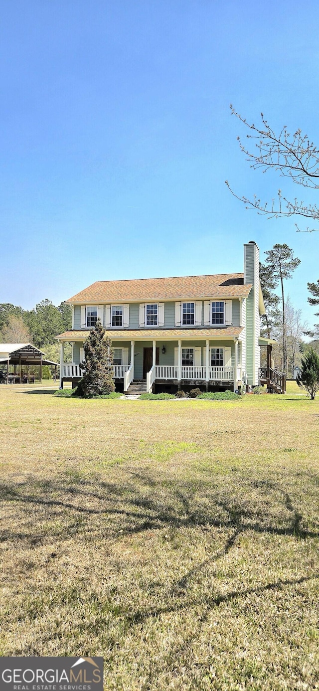 townhome / multi-family property with a chimney, a front yard, and covered porch