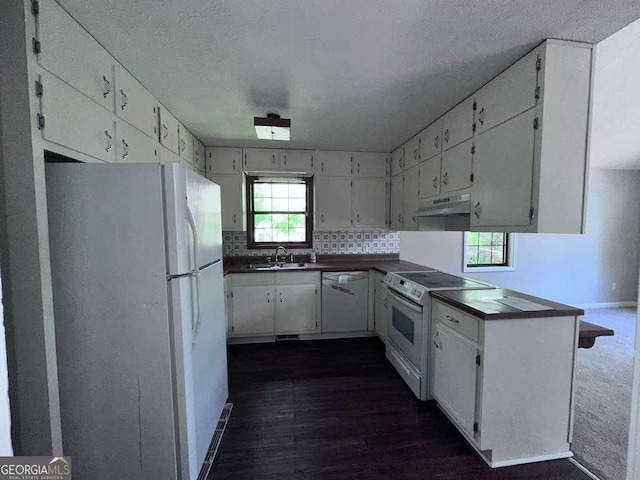 4464 Cary Dr, Snellville, GA 30039 - kitchen with a sink, white appliances, under cabinet range hood, white cabinets, and dark countertops
