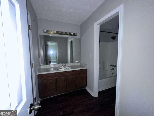 4464 Cary Dr, Snellville, GA 30039 - full bath with wood finished floors, vanity, a textured ceiling,  shower combination, and baseboards