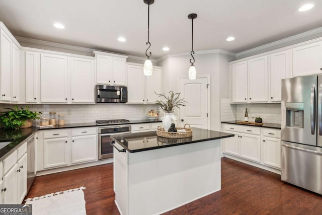 kitchen with stainless steel appliances, dark countertops, crown molding, white cabinetry, and decorative backsplash