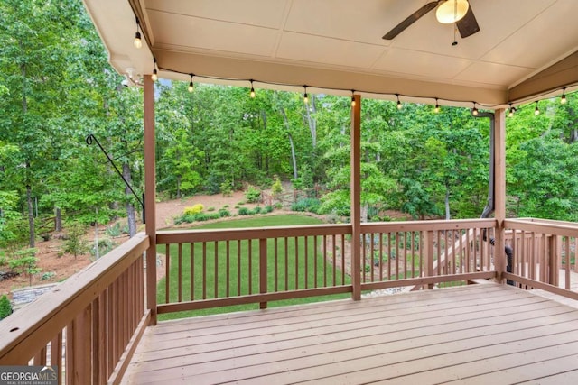 deck featuring a ceiling fan and a yard