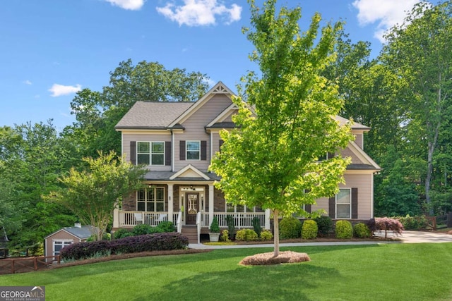 craftsman-style house with covered porch, a front yard, and stone siding