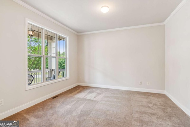 carpeted spare room featuring ornamental molding and baseboards