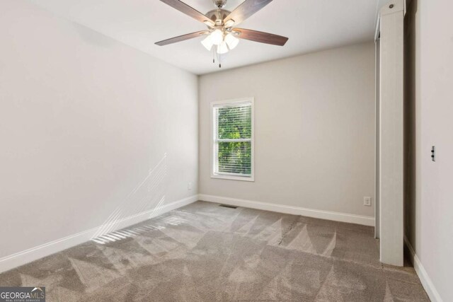 spare room featuring carpet floors, baseboards, and a ceiling fan