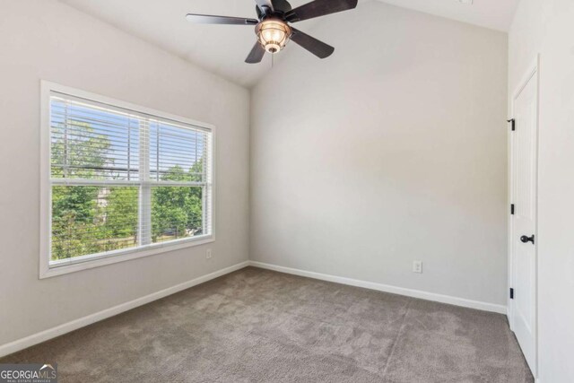empty room with carpet floors, lofted ceiling, baseboards, and a ceiling fan
