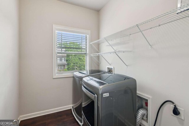laundry area with separate washer and dryer, dark wood-style floors, and baseboards