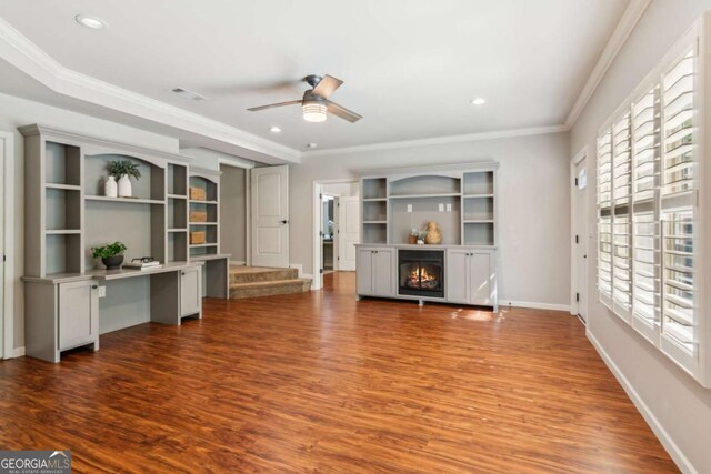 unfurnished living room featuring ceiling fan, wood finished floors, recessed lighting, crown molding, and a lit fireplace