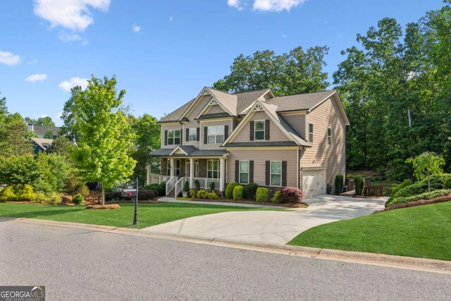view of front of house featuring concrete driveway, an attached garage, covered porch, and a front lawn