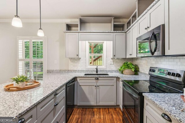 kitchen with stainless steel microwave, range with electric cooktop, black dishwasher, a sink, and backsplash
