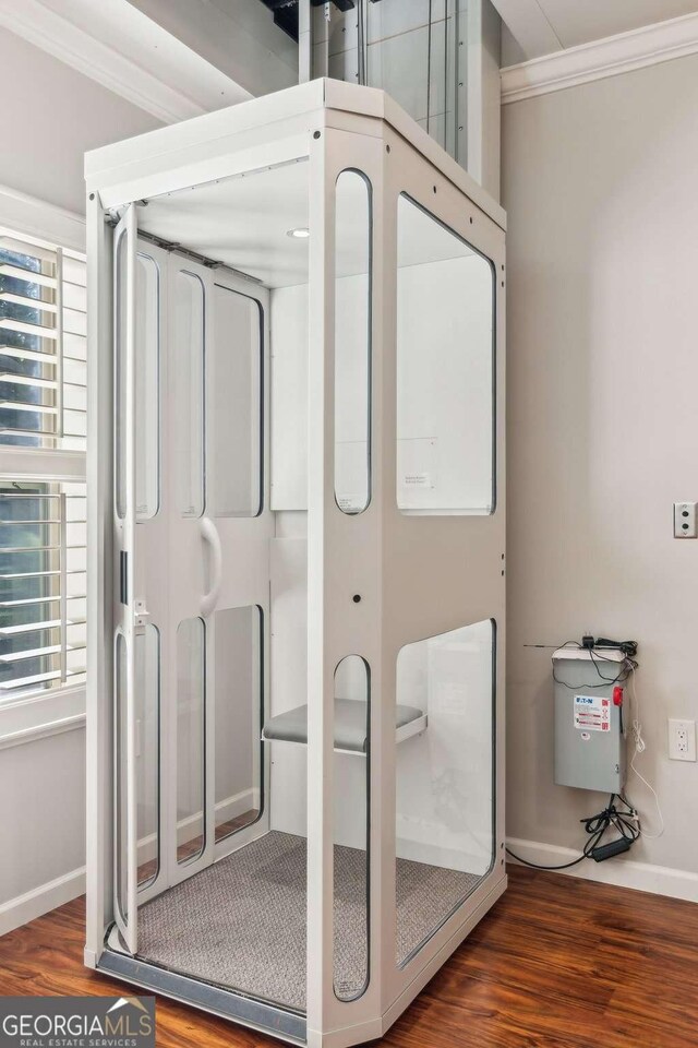 bathroom featuring crown molding, wood finished floors, and baseboards