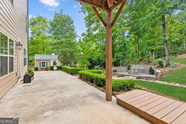 view of patio / terrace with an outbuilding and view of scattered trees