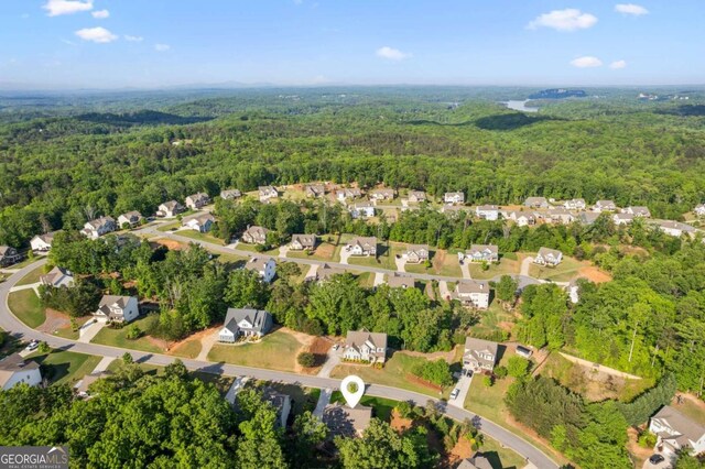 aerial view of property's location with a forest and nearby suburban area