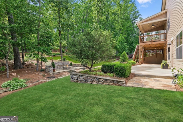 view of grassy yard with ceiling fan, stairs, a patio, and a deck