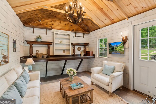 living area featuring wood walls, wood finished floors, wood ceiling, plenty of natural light, and lofted ceiling