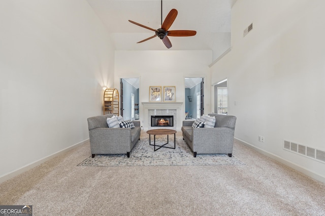 living room with high vaulted ceiling, ceiling fan, carpet, a fireplace, and baseboards