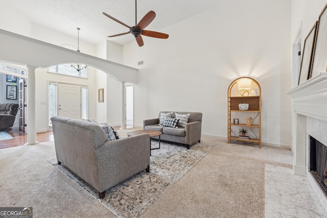 1020 Regency Dr, Acworth, GA 30102 - living area with ornate columns, arched walkways, carpet flooring, a ceiling fan, and a high ceiling