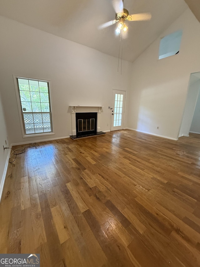 6449 Pinebark Way, Morrow, GA 30260 - unfurnished living room featuring high vaulted ceiling, wood-type flooring, a ceiling fan, a glass covered fireplace, and baseboards