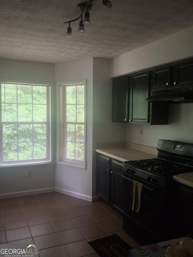 6449 Pinebark Way, Morrow, GA 30260 - kitchen with black gas range, under cabinet range hood, tile patterned flooring, baseboards, and dark cabinets
