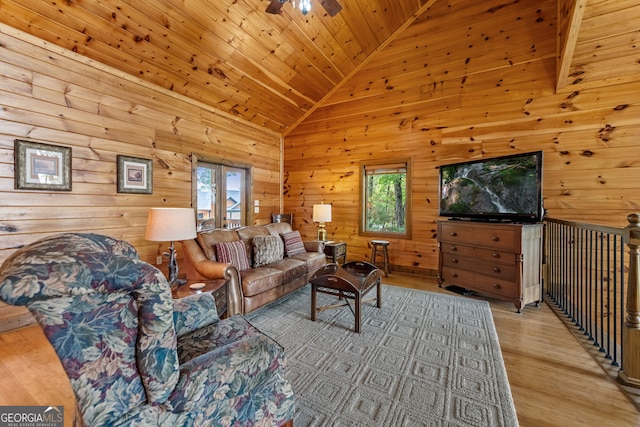 living area with lofted ceiling, wooden walls, wooden ceiling, light wood-type flooring, and ceiling fan