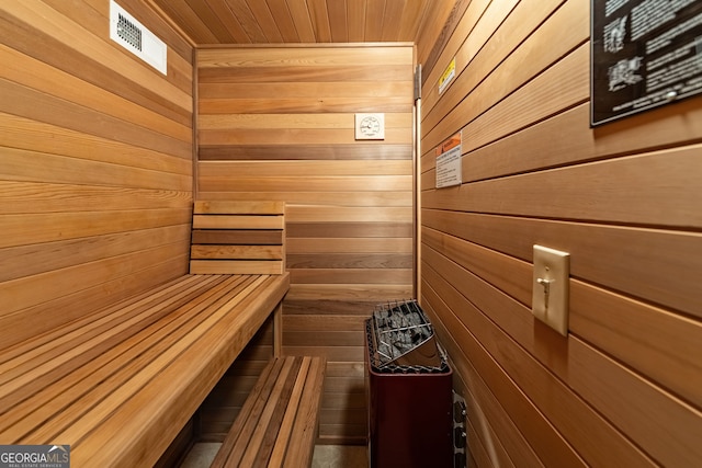 relaxing sauna featuring wood walls
