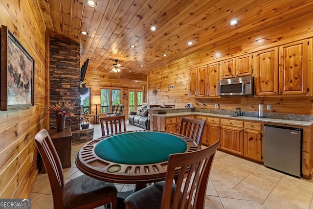 dining area with recessed lighting, ceiling fan, wood ceiling, light tile patterned floors, and wooden walls