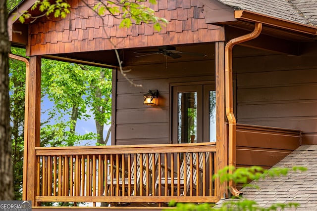 view of exterior entry featuring a ceiling fan and roof with shingles