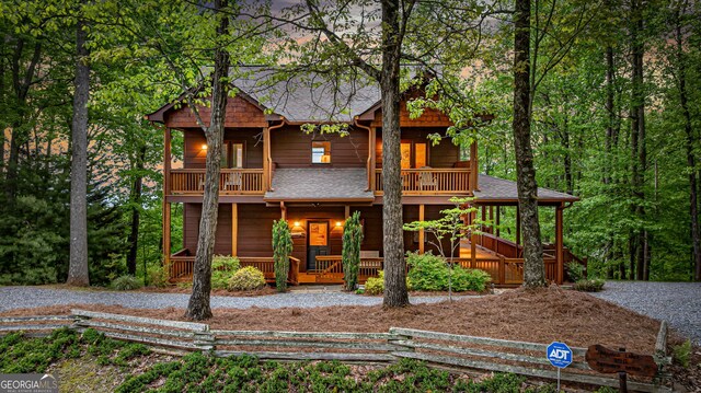 view of front of home featuring a porch, a balcony, and a shingled roof