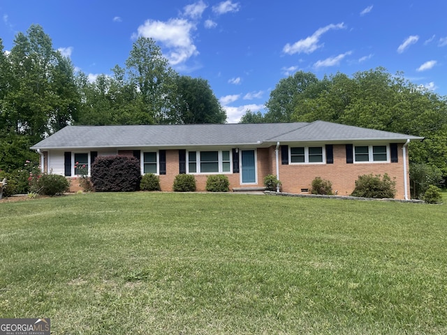ranch-style house with a front yard, brick siding, and a shingled roof