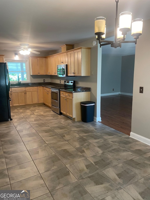 kitchen with stainless steel appliances, dark countertops, ceiling fan, light brown cabinetry, and baseboards