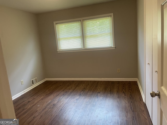 unfurnished bedroom featuring dark wood-style flooring and baseboards